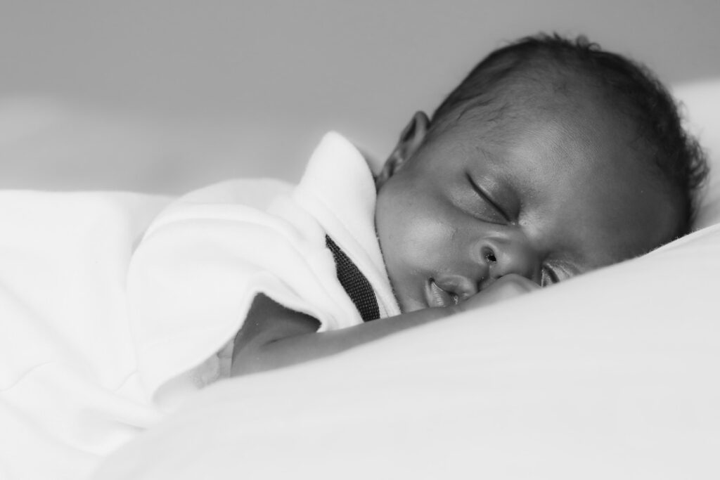 baby in white shirt lying on bed